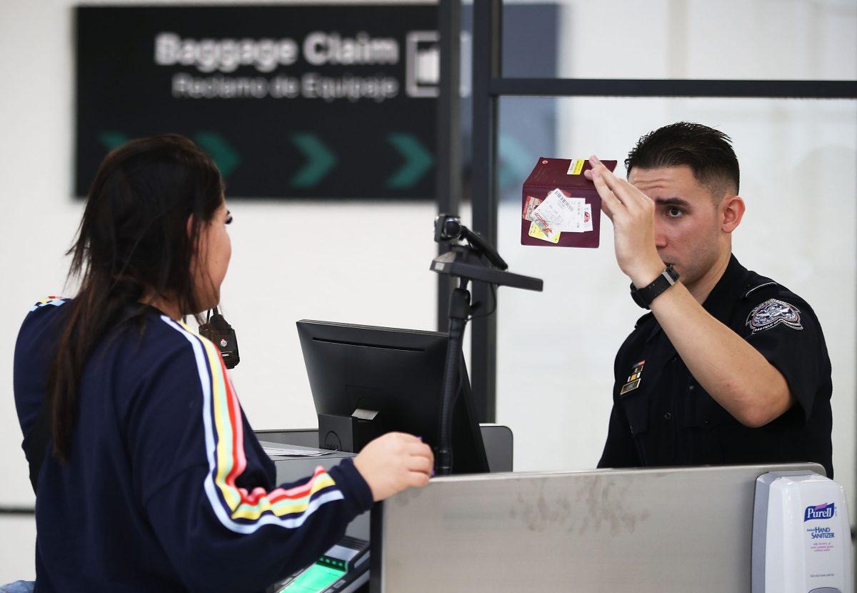 A U.S. Customs and Border Protection officer uses facial recognition technology to screen a traveler entering the United States at Miami International Airport, on Feb. 27, 2018. (Joe Raedle/Getty Images)