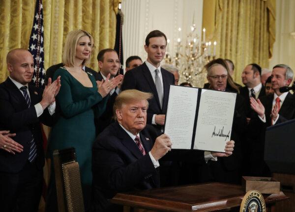 President Donald Trump holds up a signed executive order in the White House, on Dec. 11, 2019. (Mark Wilson/Getty Images)