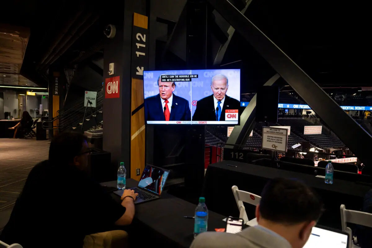 Former President Donald J. Trump and President Joe Biden through a screen from the media file center during the presidential debate in Atlanta, Ga., on June 27, 2024. (Madalina Vasiliu/The Epoch Times)