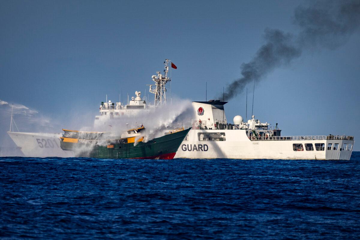 A Chinese Coast Guard ship fires a water cannon at Unaizah May 4, a Philippine Navy chartered vessel, conducting a routine resupply mission to troops stationed at Second Thomas Shoal, in the South China Sea on March 5, 2024. (Ezra Acayan/Getty Images)