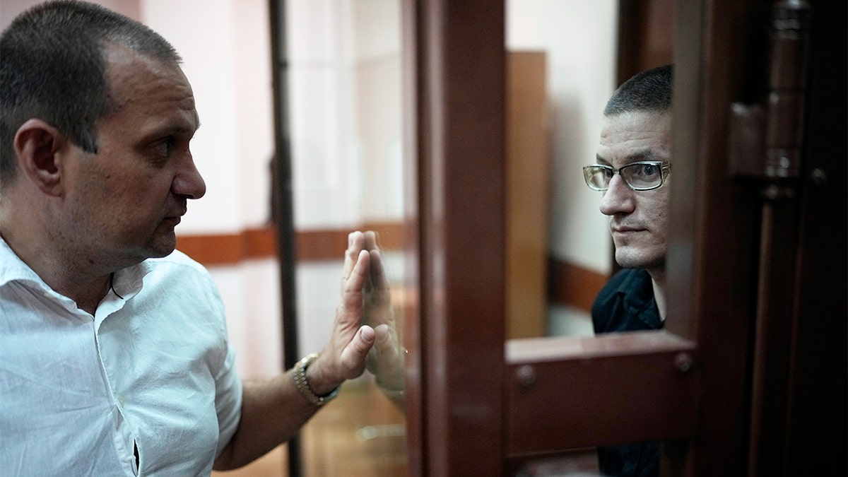 Robert Woodland sitting in glass cage in Russian court