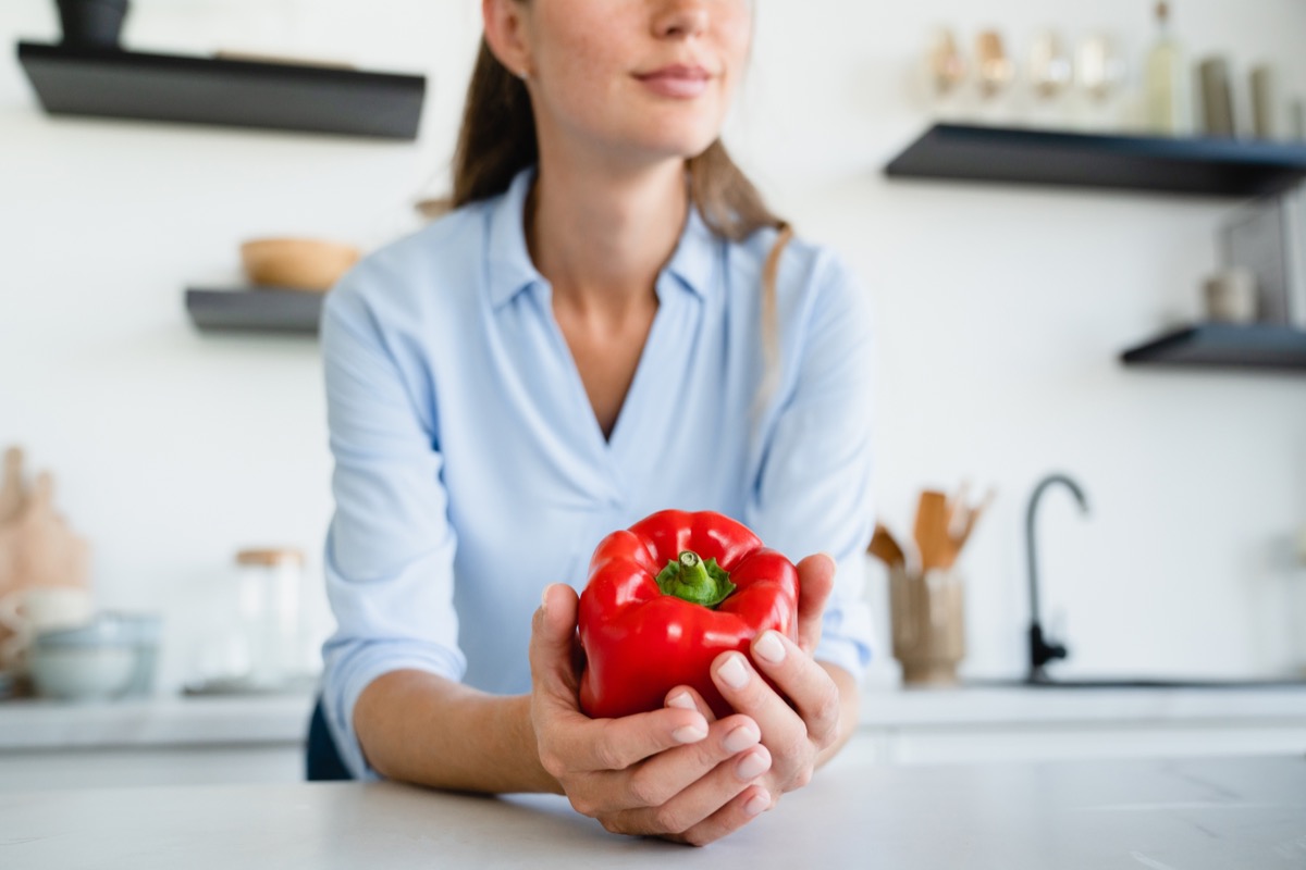woman holding red bell pepper