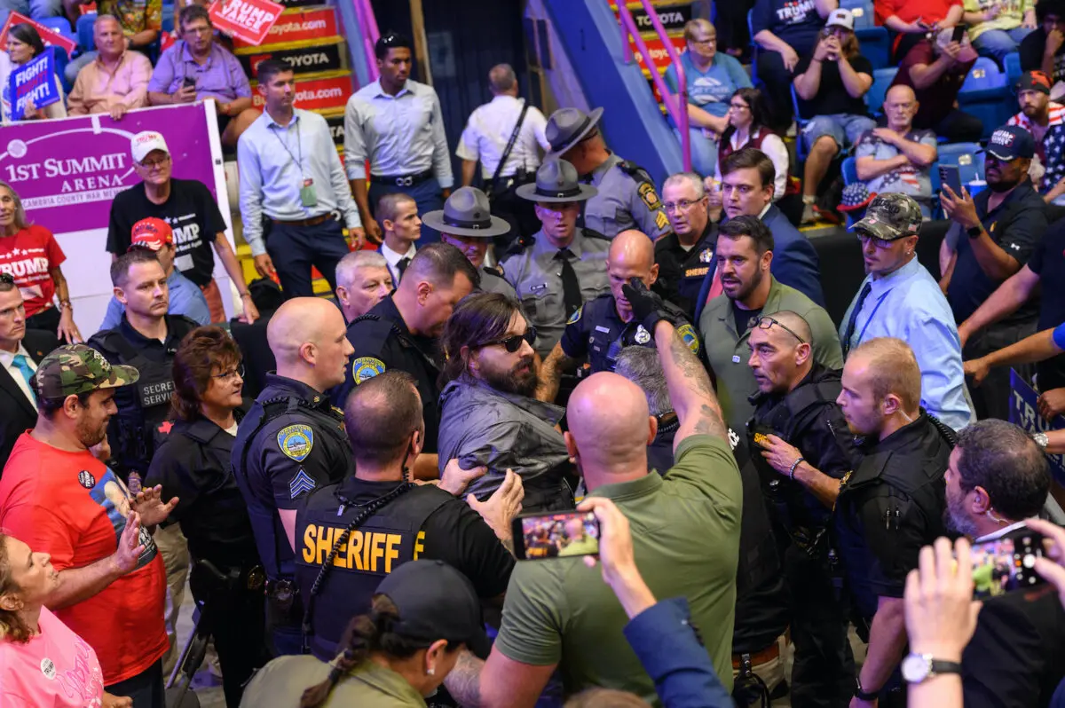 A man is apprehended by security and police after jumping onto the media platform at a campaign rally for Republican presidential nominee, former President Donald Trump at the 1st Summit Arena in Johnstown, Pa., on Aug. 30, 2024. (Justin Merriman/Getty Images)