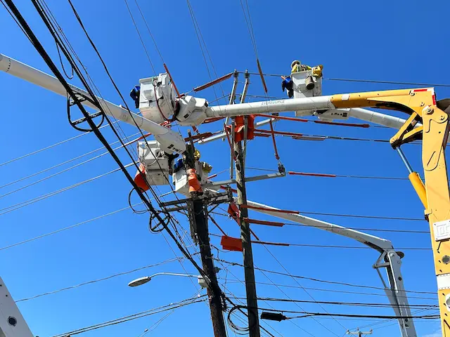 Billy Lang and fellow Eversource electrical linemen upgrade a transmission line from elevated “buckets” above a busy street in a western Connecticut town. (Courtesy Billy Lang)