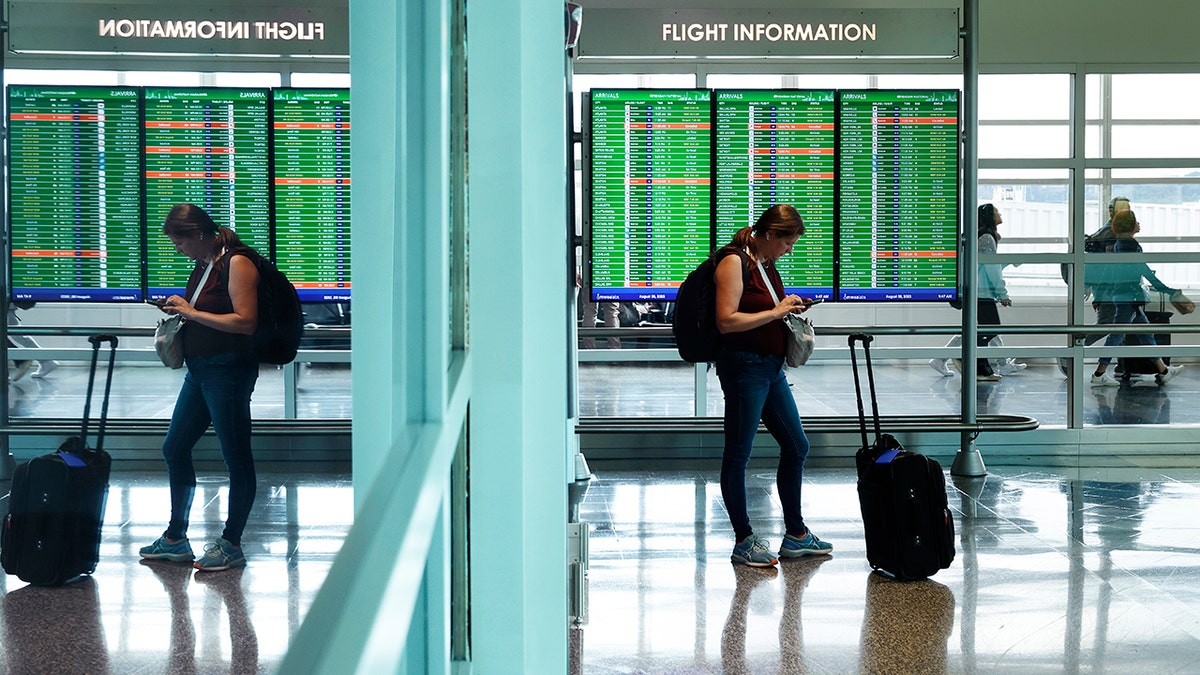 Traveler checks phone at Reagan National Airport in the Washington area