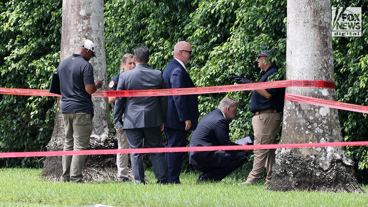 FBI investigators gather evidence from the perimeter of Trump International Golf Club in West Palm Beach