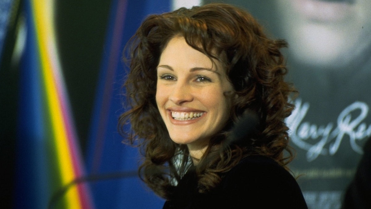 Julia Roberts with curly hair smiles for a photo in Berlin