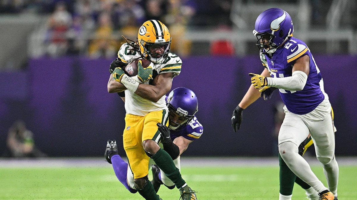 Aaron Jones runs with a football