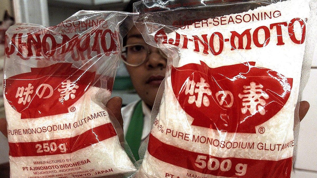 Woman holding bags of MSG.