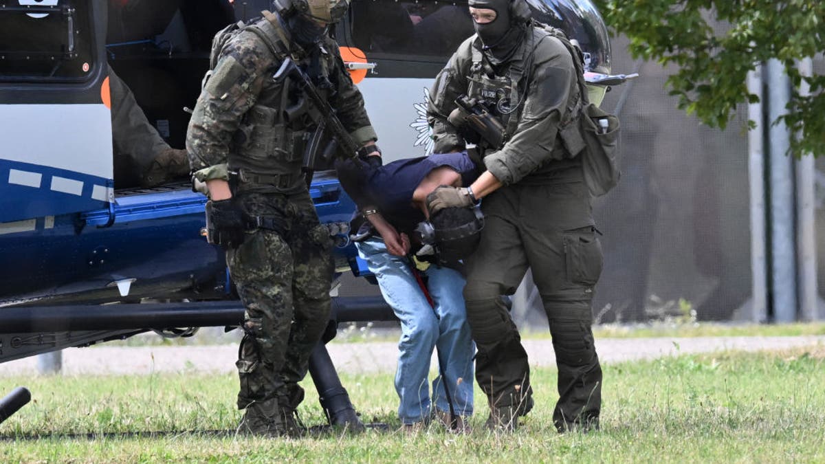 Members of a special police unit escort a man suspected to be responsible for the Solingen knife attack from a helicopter to the Office of the Federal Prosecutor in Karlsruhe, Germany, on Aug. 25, 2024. Police arrested the suspect in a raid at a hostel for asylum seekers on August 24, 2024, not far from the scene of the random attack during festivities to celebrate the 650th anniversary of Solingen, western Germany. Authorities said that the Syrian man had given himself up and confessed to killing three people and wounding several others in a knife rampage at a street festival.