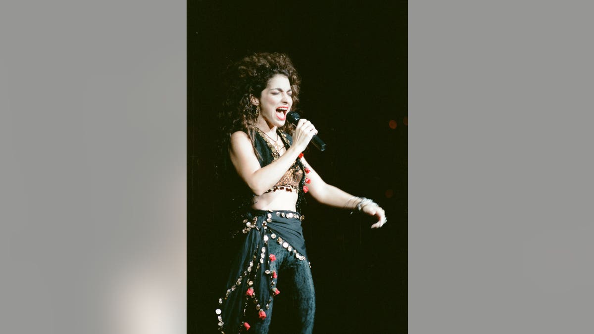 Gloria Estefan flashes her abs in a crop top and slacks