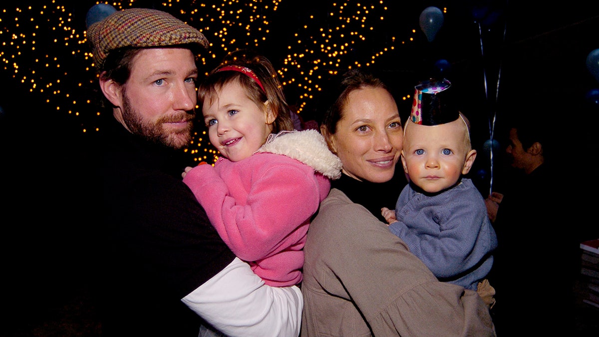 Ed Burns and Christy Turlington holding their two children.