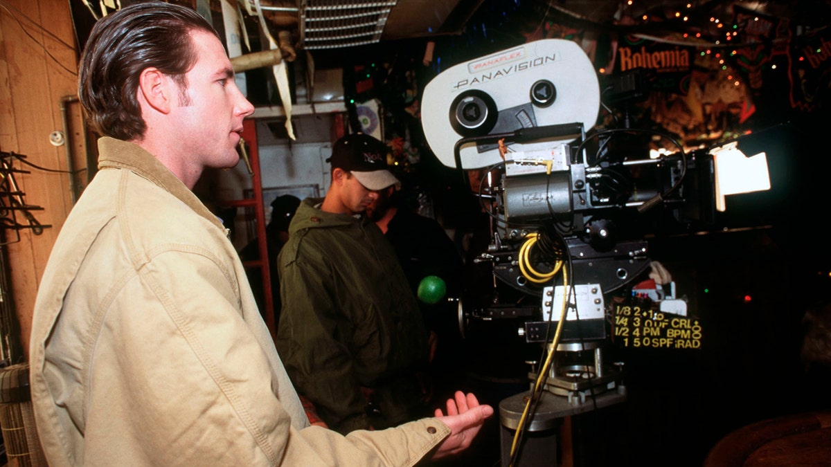 A young Ed Burns filming with a camera.