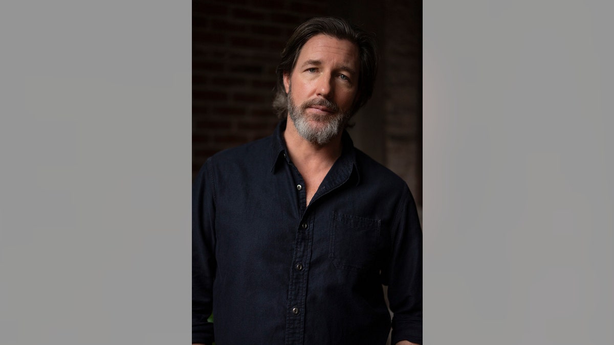 Ed Burns wearing a dark shirt.