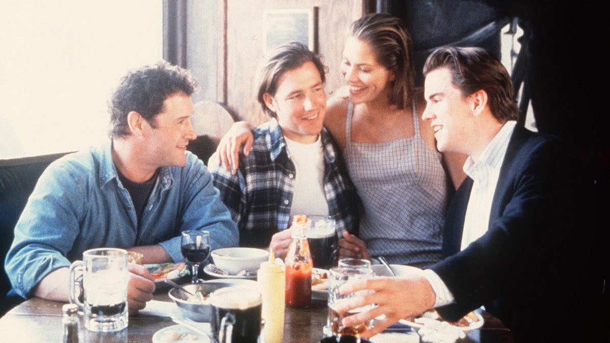 The Brothers McMullen cast posing together in front of a table