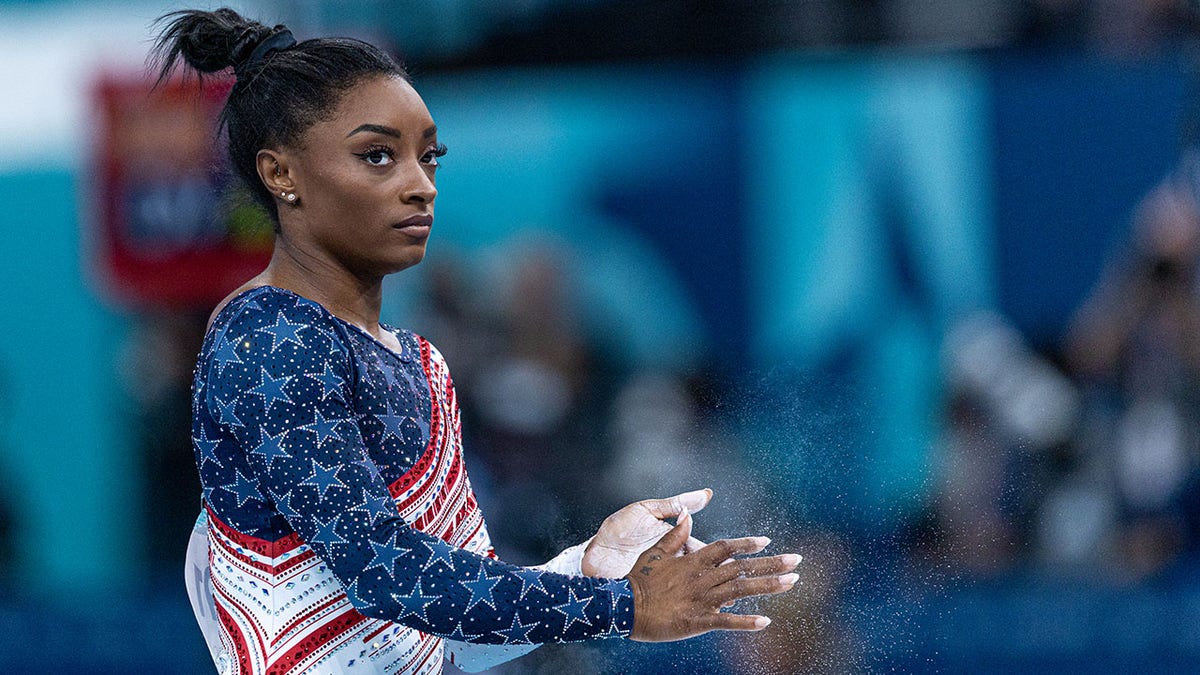 Simone Biles clasps her hands