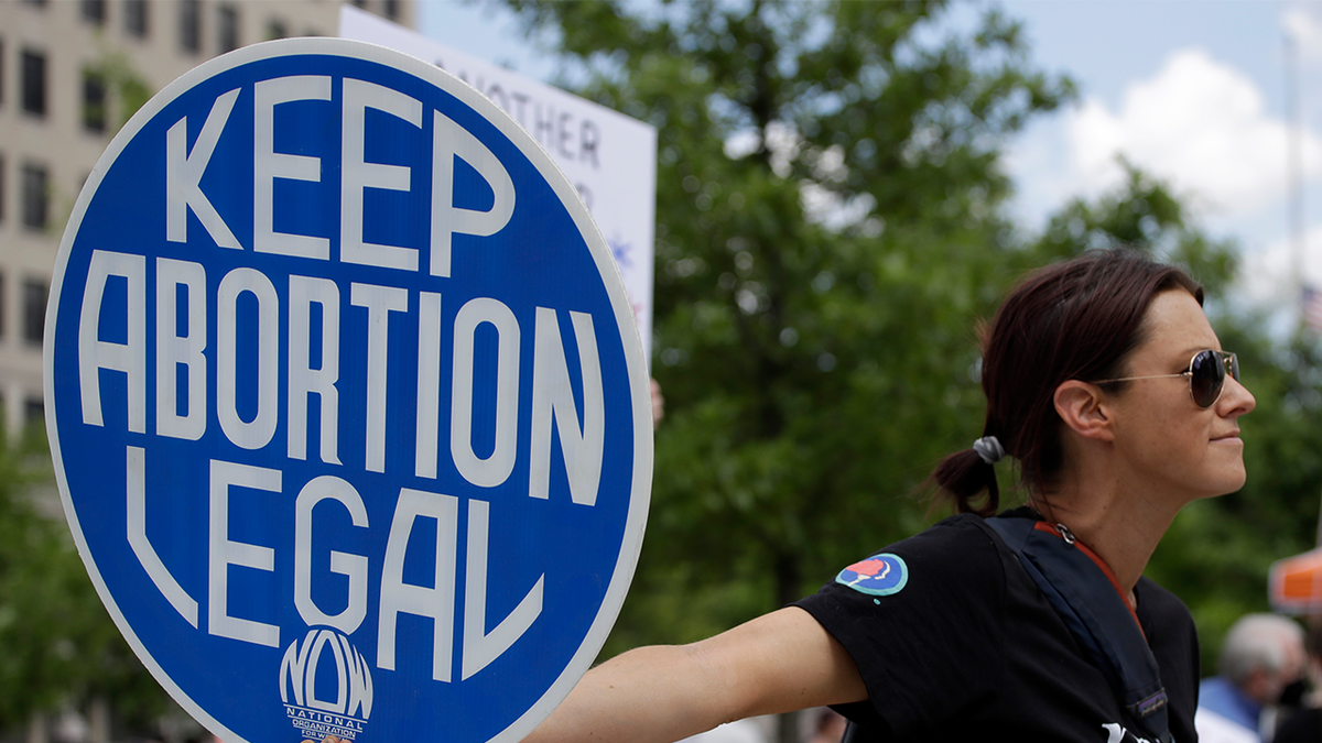 An abortion-rights protester with 'Keep abortion legal' sign