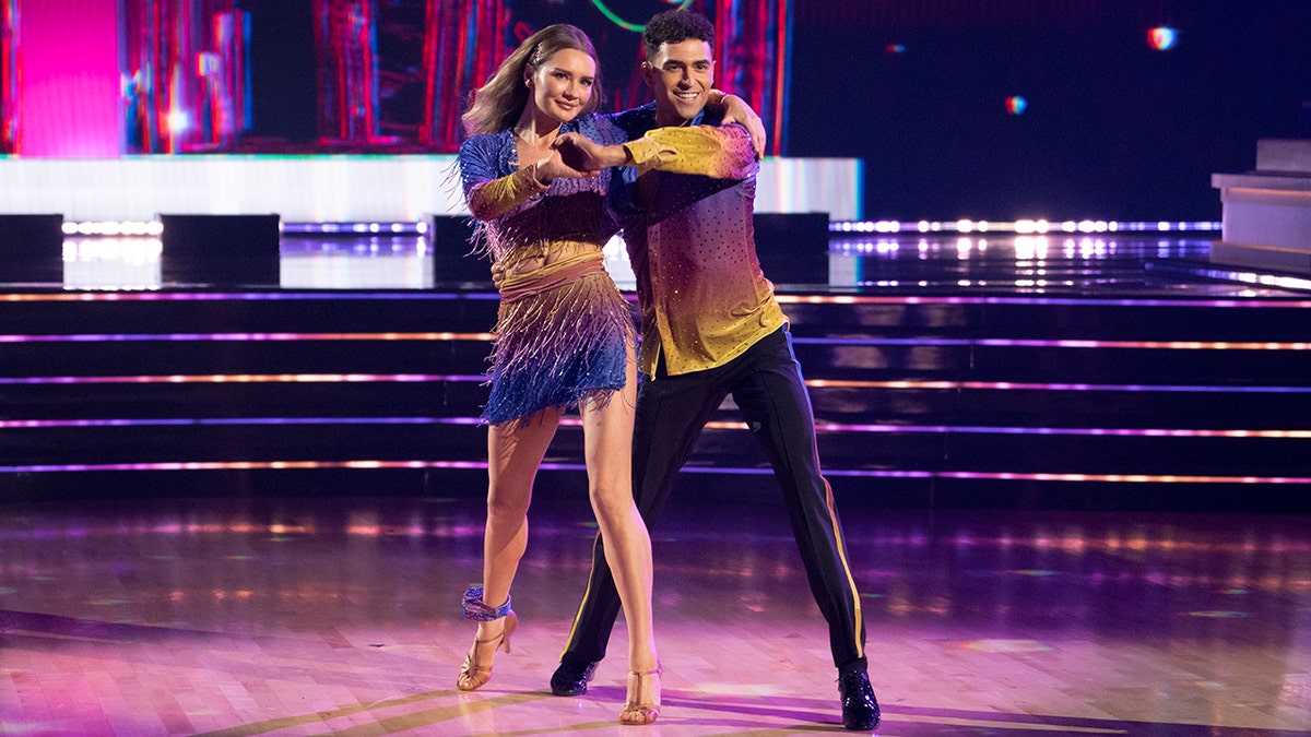 Anna 'Delvey' Sorokin and Ezra Sosa in a matching purple and yellow attire dance on 