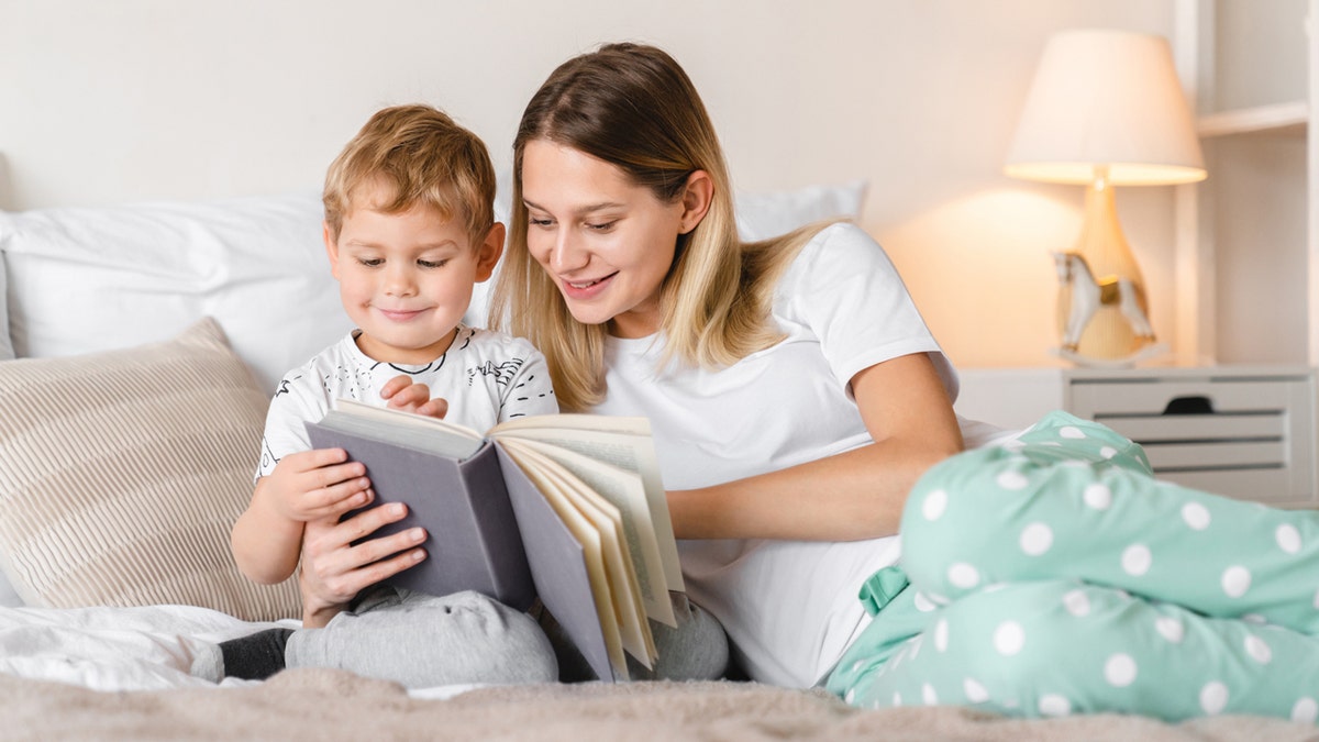 Mom and young son reading a book together