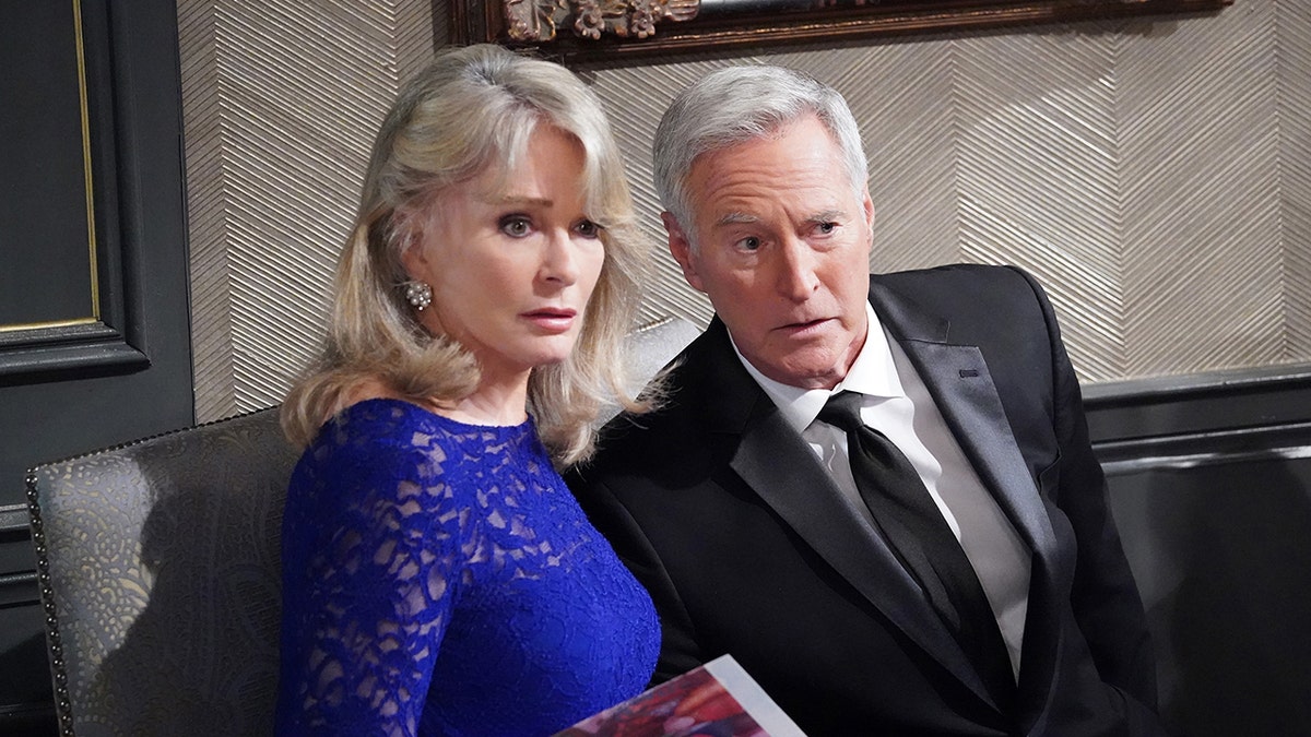 Deirdre Hall in a blue dress as Marlena Evans and Drake Hogestyn in a black suit and tie as John Black in a still from 