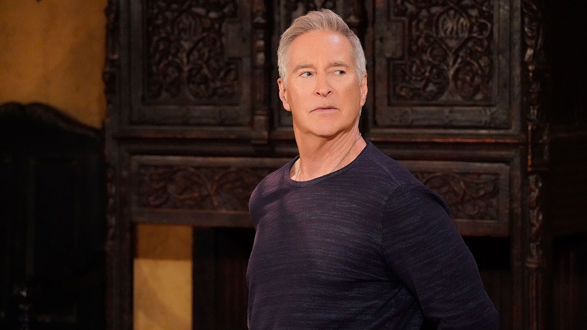 Drake Hogestyn as John Black looking to his left in a serious still from 