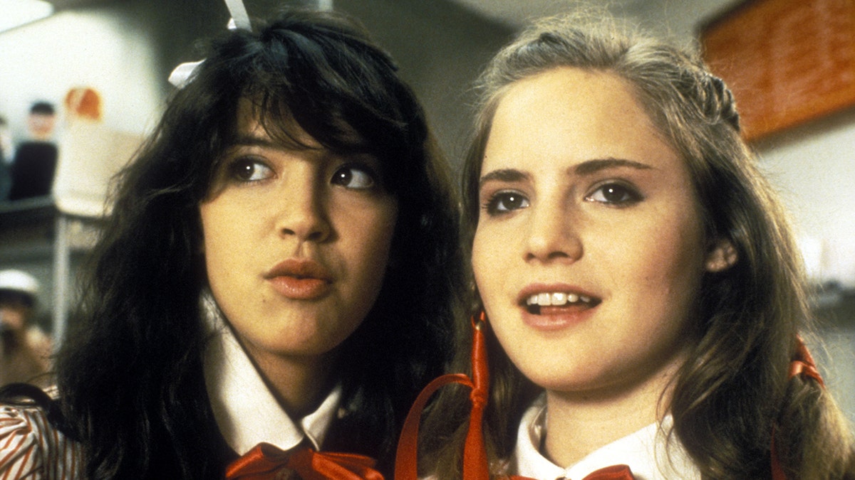 Phoebe Cates and Jennifer Jason Leigh look off in the distance in character in 