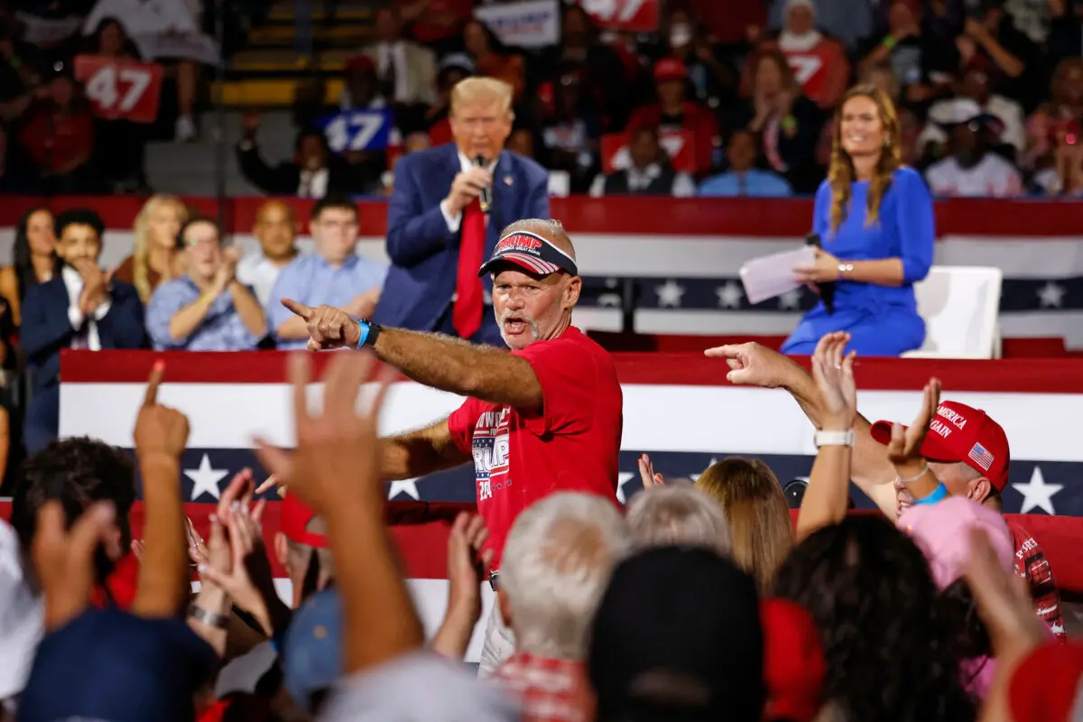 Auto Workers for Trump founder Brian Pannebecker (C) is recognized by former US President and Republican presidential candidate Donald Trump during a town hall meeting moderated by Arkansas Governor Sarah Huckabee Sanders (R) at the Dort Financial Center in Flint, Michigan, on Sept. 17, 2024. (JEFF KOWALSKY/AFP via Getty Images)