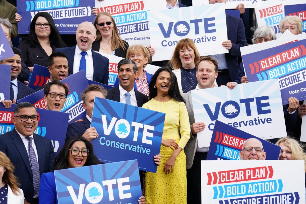 Prime Minister Rishi Sunak (C) and his wife Akshata Murty (in yellow) at the launch of the Conservative Party general election manifesto at Silverstone race track in Northamptonshire, England, on June 11, 2024. (James Manning/PA)