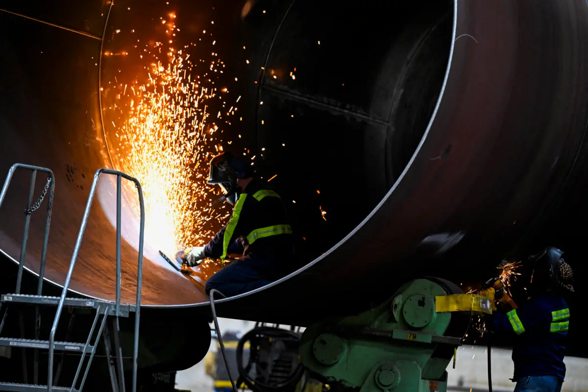 Men work on a wind turbine as US President Joe Biden tours CS Wind, the largest wind tower manufacturer in the world, in Pueblo, Colo., on Nov. 29, 2023. (Andrew Caballero-Reynolds/AFP via Getty Images)