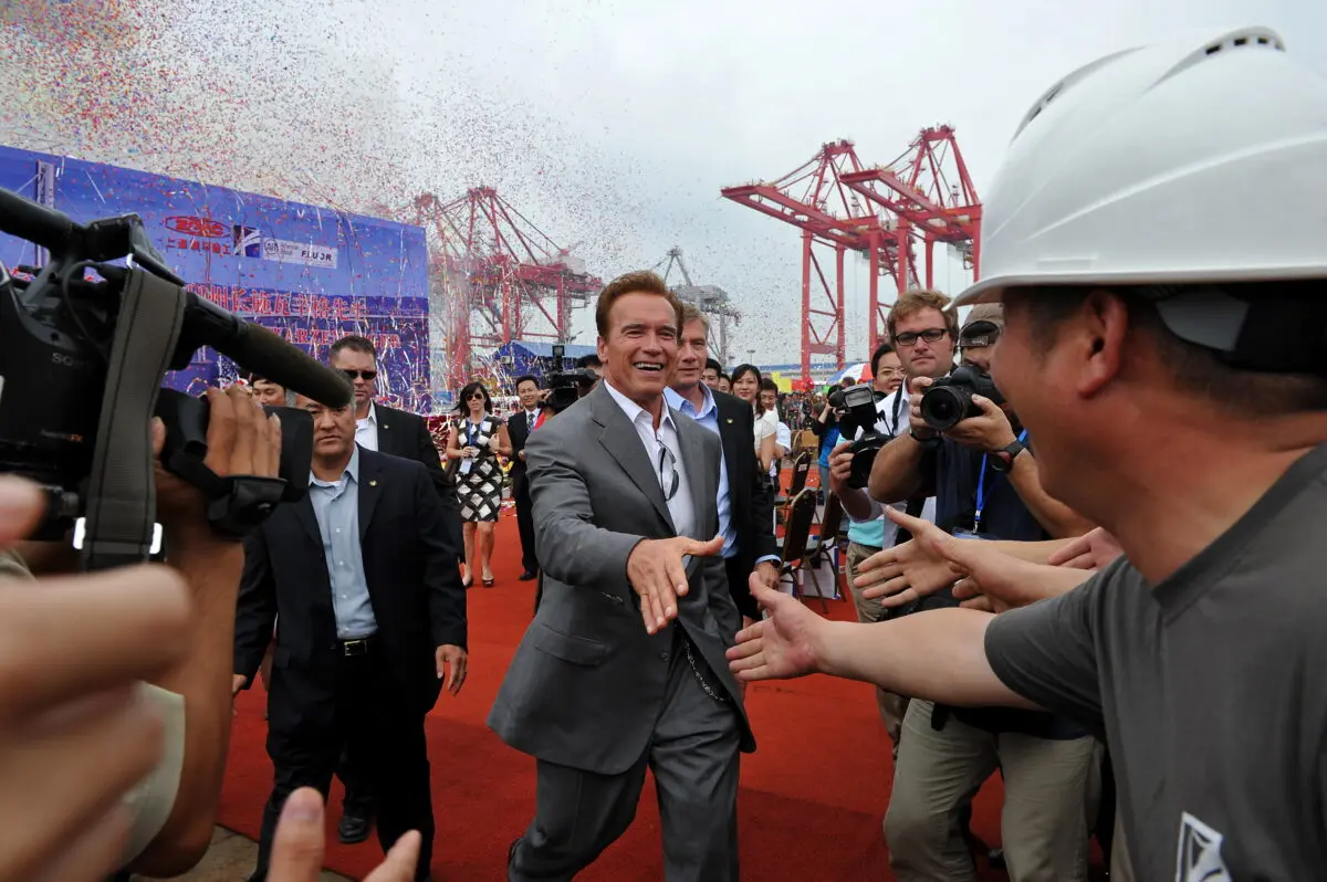 Then-California Gov. Arnold Schwarzenegger greets workers during his visit to the Zhenhua Port Machinery Company in Shanghai on Sept. 13, 2010. (Philippe Lopez/AFP via Getty Images)