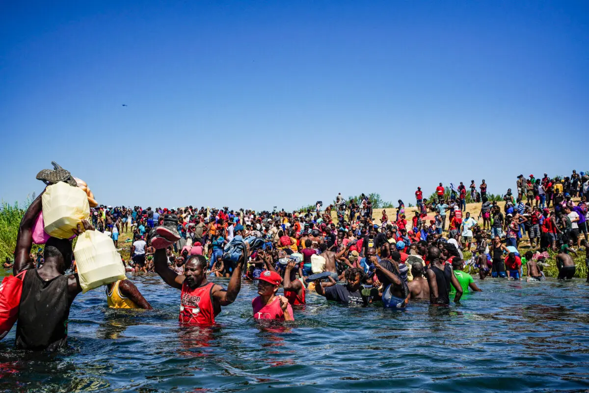 Haitian migrants, part of a group of over 10,000 people staying in an encampment on the U.S. side of the border, cross the Rio Grande river to get food and water in Mexico, after another crossing point was closed near the Acuna Del Rio International Bridge in Del Rio, Texas on Sept. 19, 2021. (Paul Ratje/AFP via Getty Images)