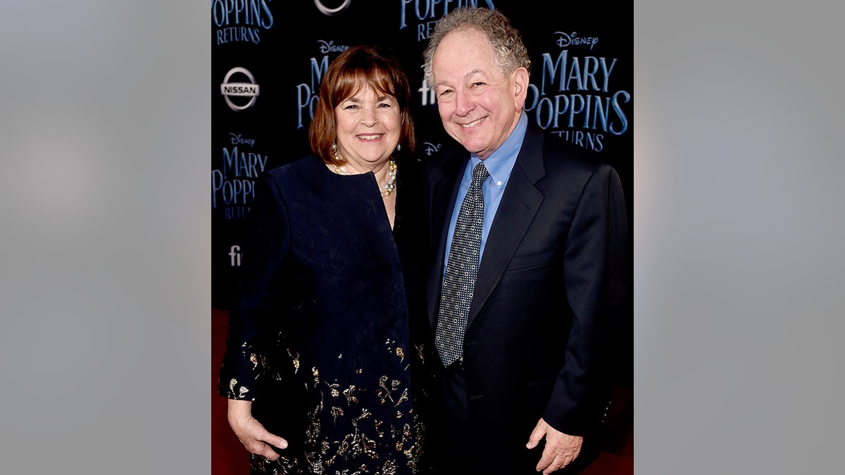 Ina and Jeffrey Garten pose on the carpet in a black dress and black suit at the 