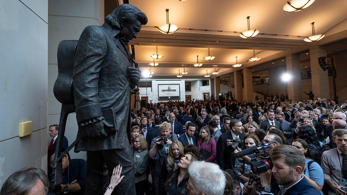 The statue depicts Cash holding a bible with his guitar slung across his back.