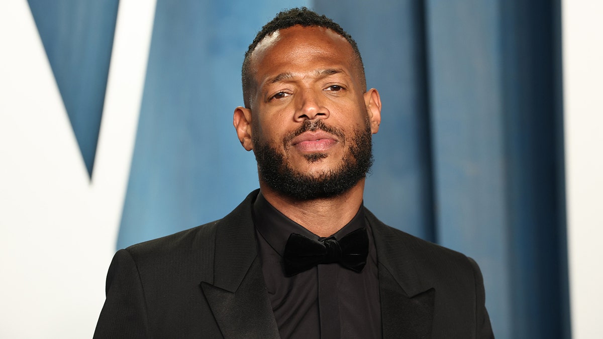 Marlon Wayans wears a black suit and shirt at the Vanity Fair Oscar party