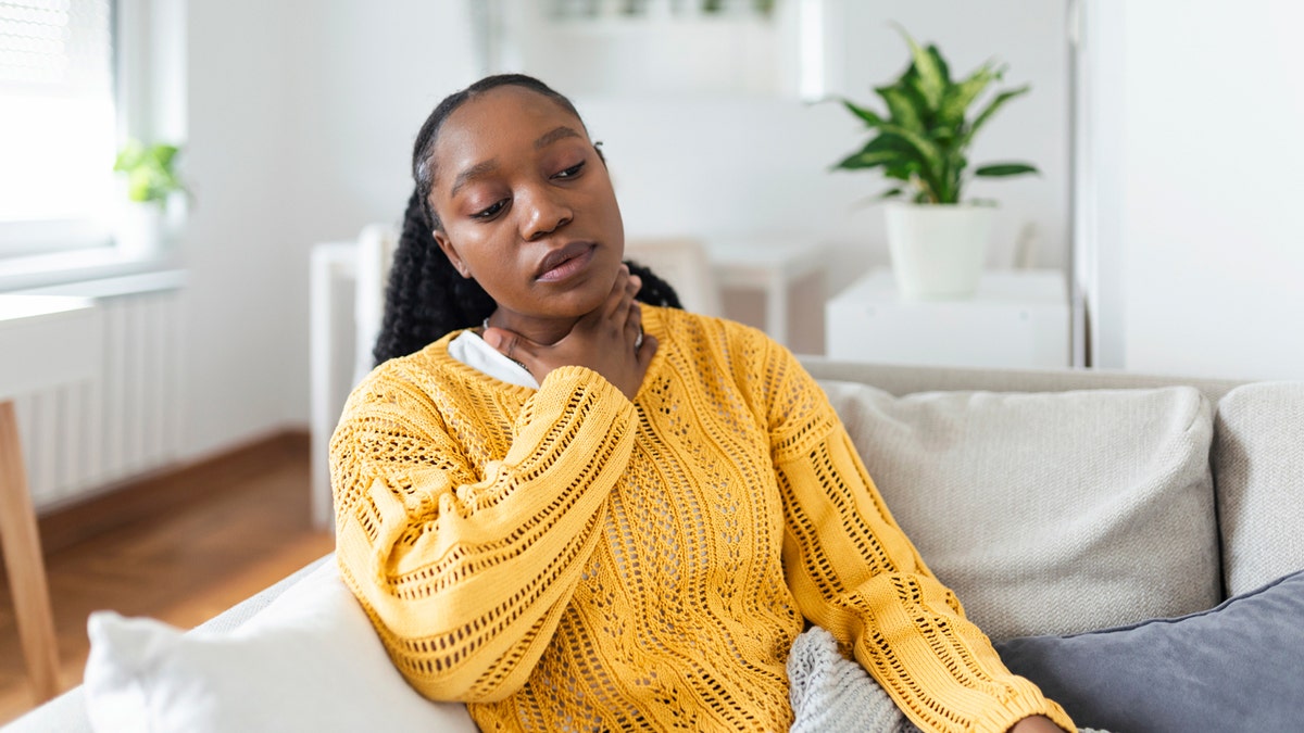 Woman holding her throat from soreness