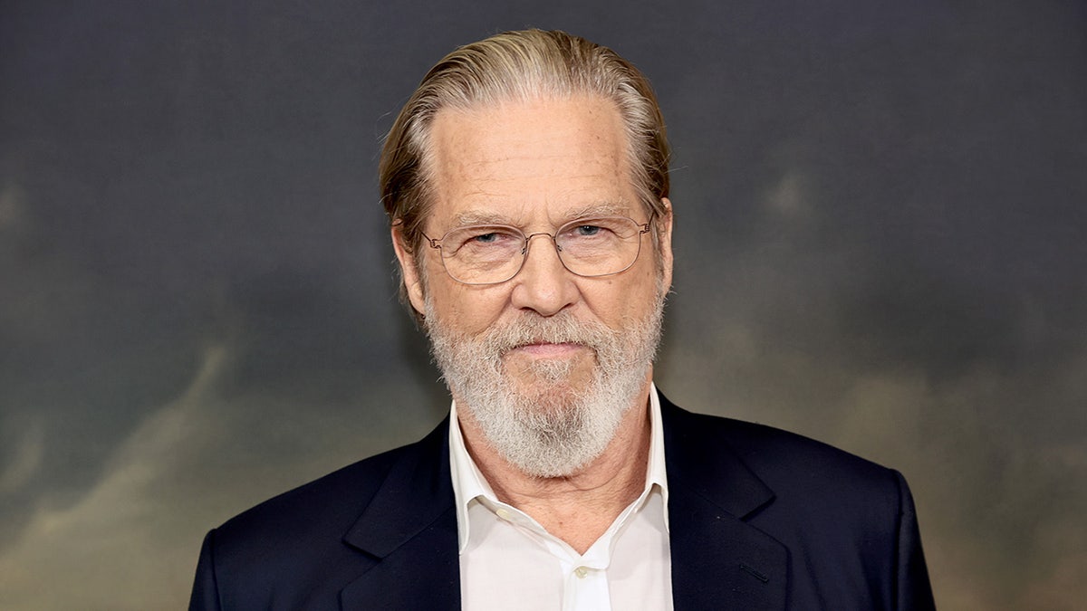 Jeff Bridges sports black coat and white shirt.