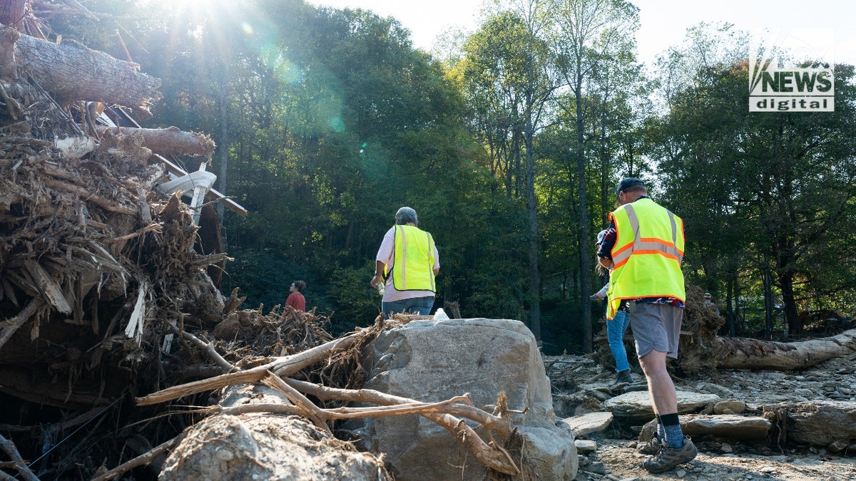 Steve Antle and his wife climb a pile of debris