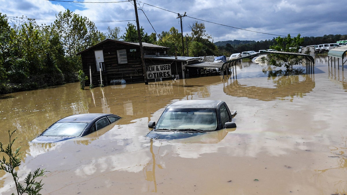 Cars sit submerged in a flooded area at a used tire dealer after Tropical Storm Helene in Hendersonville, North Carolina,