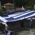 Dumb Bigot Rips Down Flag in an Act of Anti-Semitism Before Realizing it’s ACTUALLY a Greek Flag (WATCH)