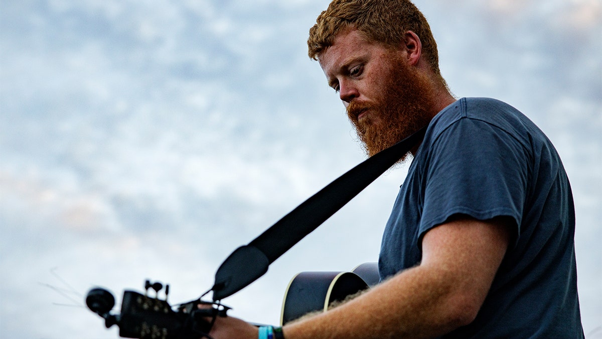 Oliver Anthony with his guitar