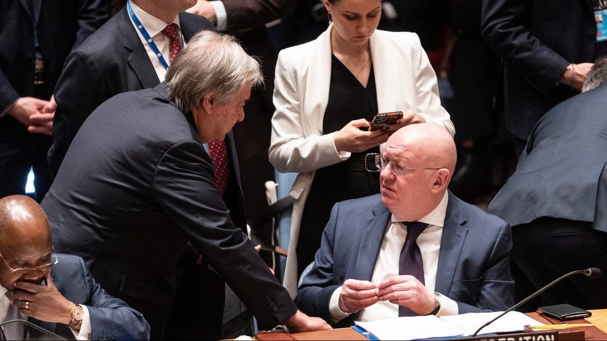 U.N. Secretary General Antonio Guterres, left, speaks with Ambassador of Russia Vassily Nebenzia