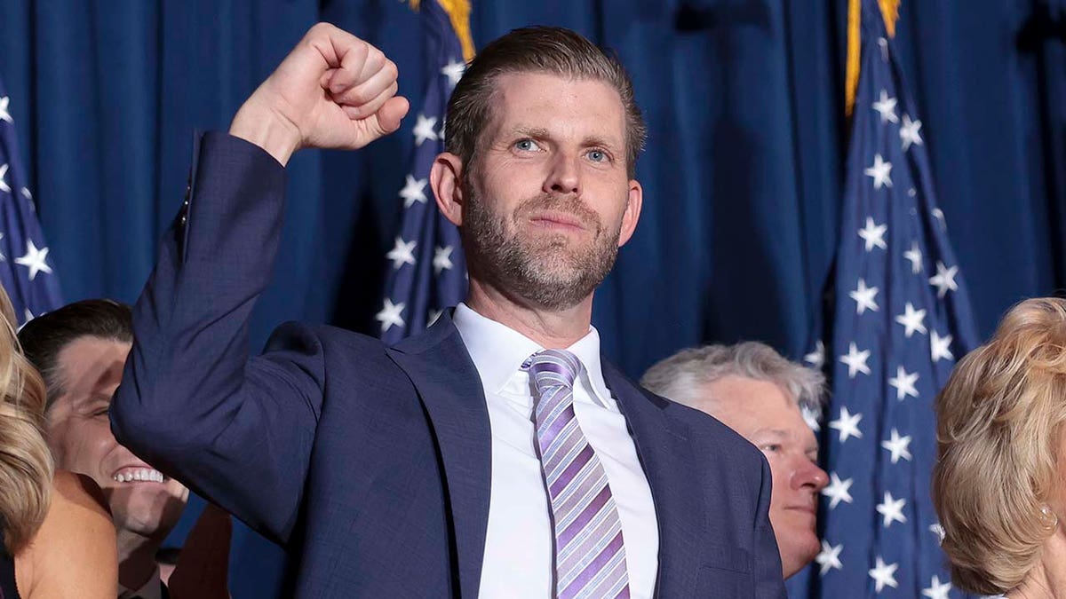 Eric Trump holds fist up.