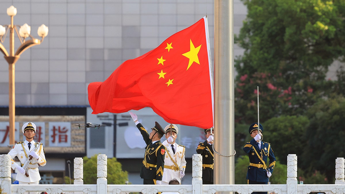 Chinese military forces surround Chinese flag