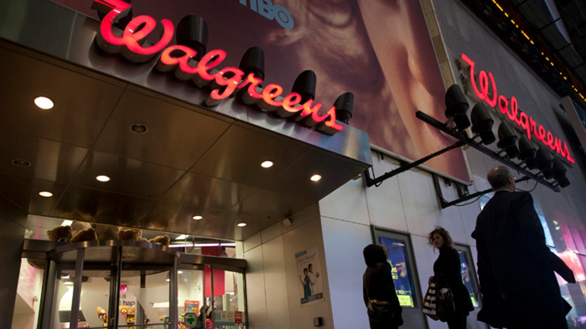 Shoppers walk by at the Walgreens' Times Square store in New York December 17, 2012. REUTERS/Andrew Kelly (UNITED STATES - Tags: BUSINESS) - RTR3BP1R