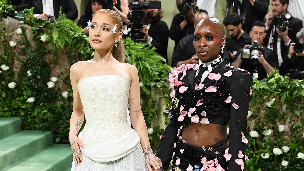 Ariana Grande and Cynthia Erivo holding hands on the Met Gala stairs