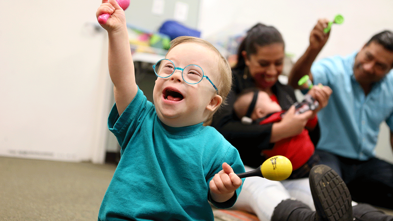 A child with down syndrome laughs in music class 