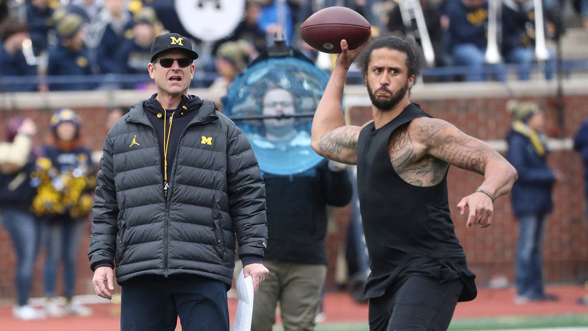 Jim Harbaugh watches Colin Kaepernick throw a pass