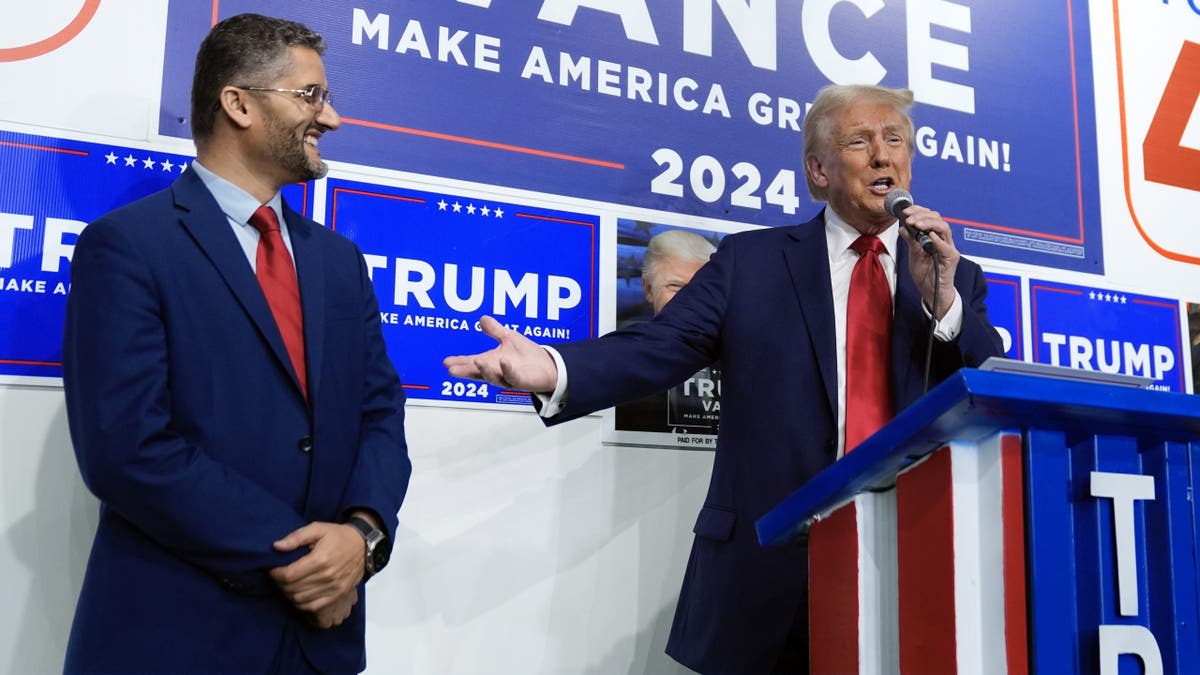 Republican presidential nominee former President Donald Trump speaks as Hamtranck Mayor Amer Ghalib listens at a campaign office, Friday, in Hamtranck, Mich.