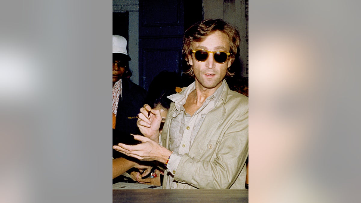 John Lennon signing autographs