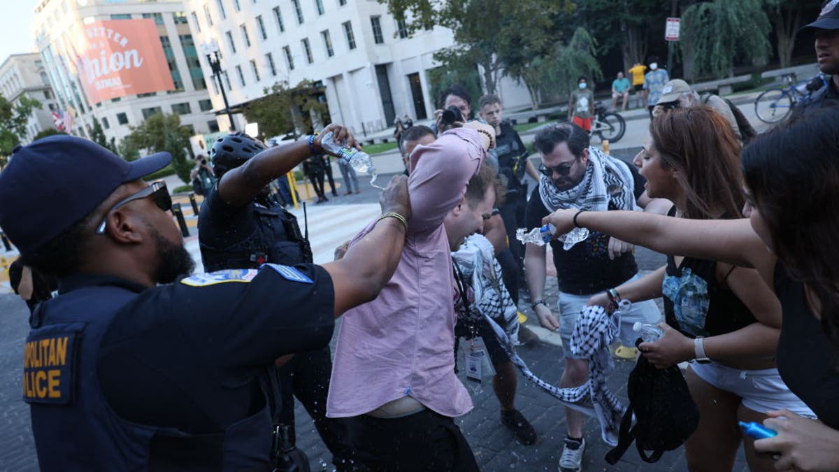 Police help a man who set himself on fire as people demonstrate to mark one year of the war between Hamas and Israel in front of the White House in Washington, DC, on October 5, 2024.